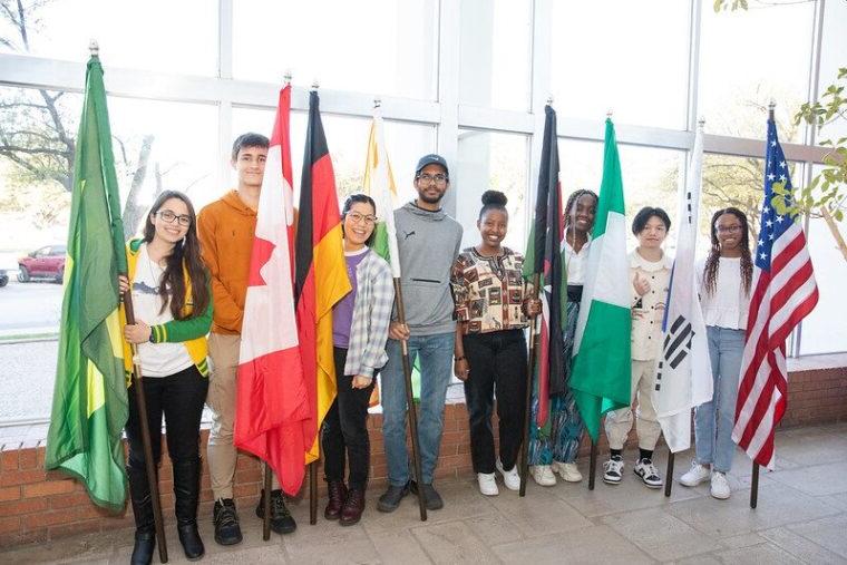 Students stand next to 的ir countries' flags during last year's I国际 Week.